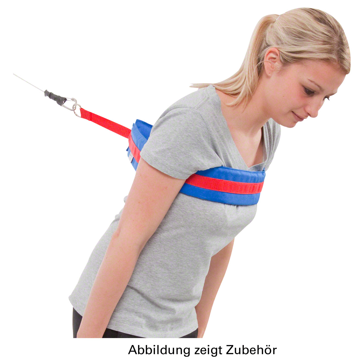 A young woman is training with a padded cable strap around her shoulders and upper chest. The blue strap with a red stripe is attached at the back to a red band, carabiner and resistance cable.