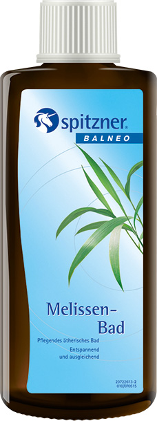 Flacon marron foncé Spitzner Balneo Bain à la mélisse, avec bouchon à vis blanc strié. Étiquette bleue avec nom de marque, logo licorne et mention BALNEO. Plante verte. Texte : relaxant, équilibrant, huiles essentielles.