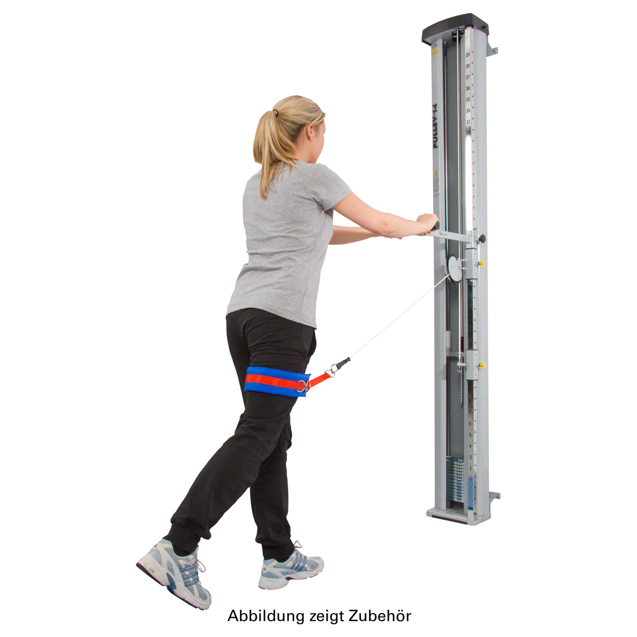 A woman in sportswear is training on the cable machine. She is standing sideways, with her back slightly turned towards the viewer, and is performing a lateral leg movement. A red and blue padded strap on her right thigh is attached to the cable.
