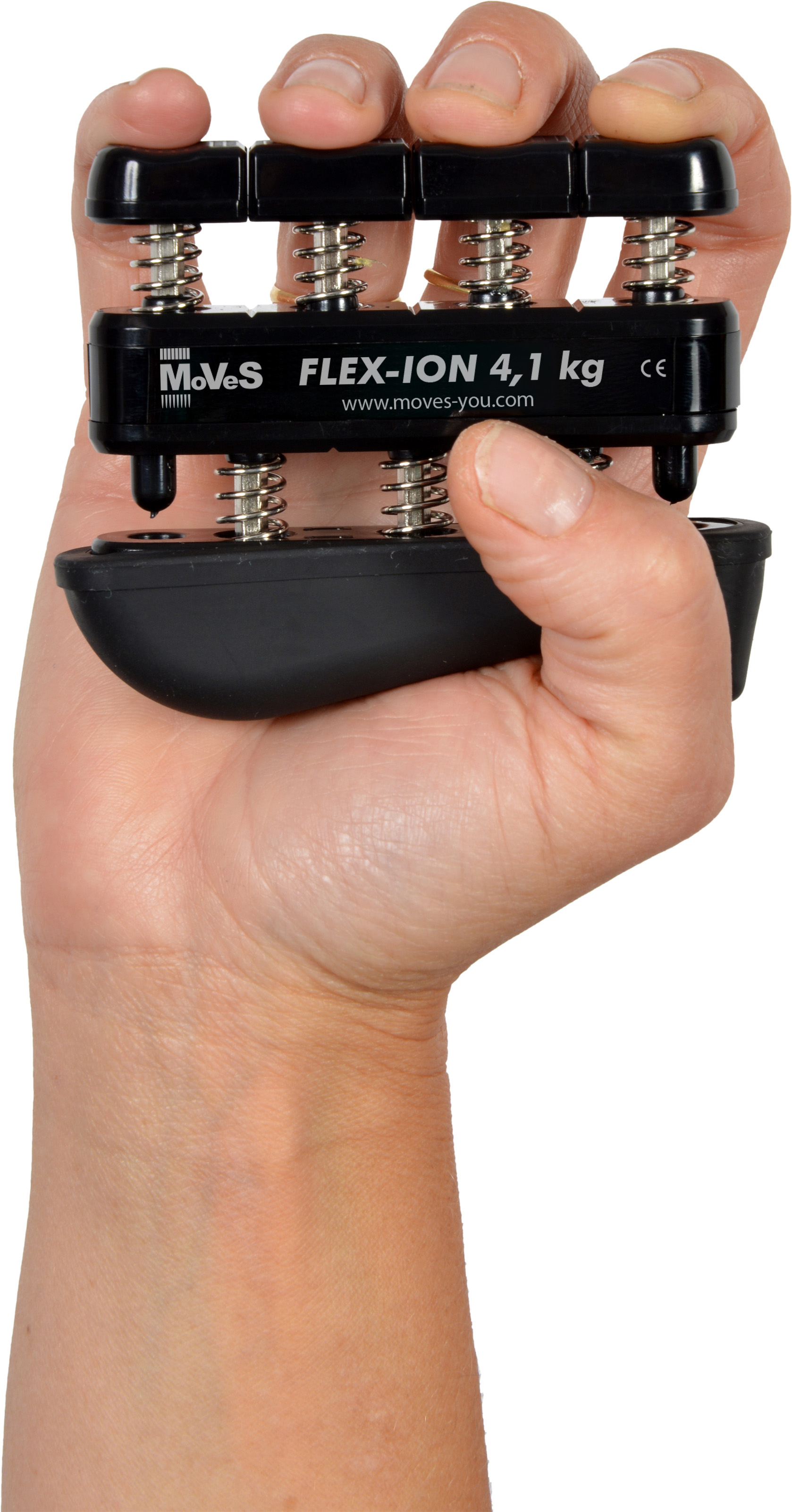 One hand is holding a black Moves Flex-Ion hand trainer. The device has four spring-loaded buttons which the fingers press to train the individual strength of each finger. The resistance level ‘FLEX-ION 4.1 kg’ is visible on the trainer.