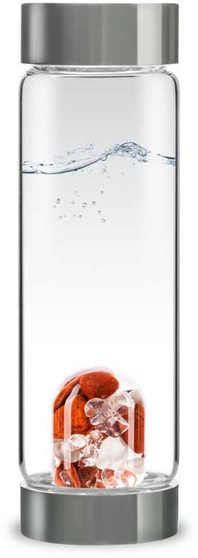 A transparent glass drinking bottle with silver metal caps at the top and bottom, filled with clear water featuring gentle ripples and rising bubbles. At the bottom is a separate clear module containing orange stones and light-coloured crystals.