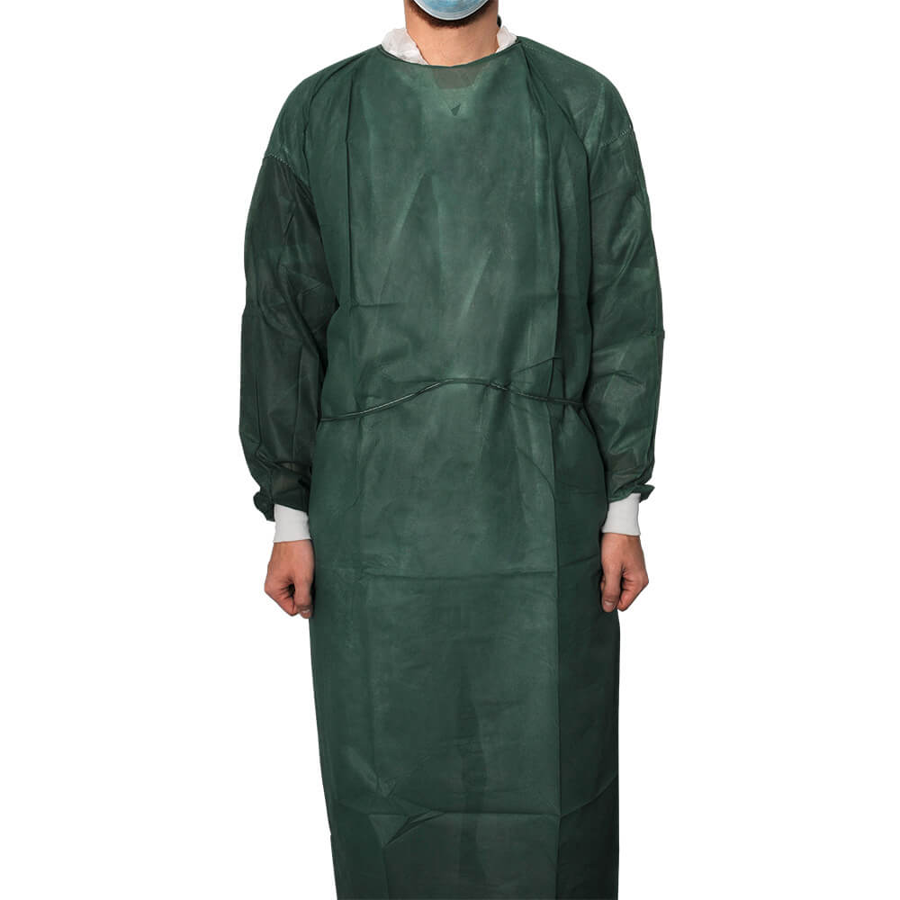La personne porte une blouse de protection vert foncé en non-tissé, aux genoux, manches longues, poignets en coton clair, liens à la taille. Un masque chirurgical bleu recouvre le bas du visage. Respirante, hydrofuge.