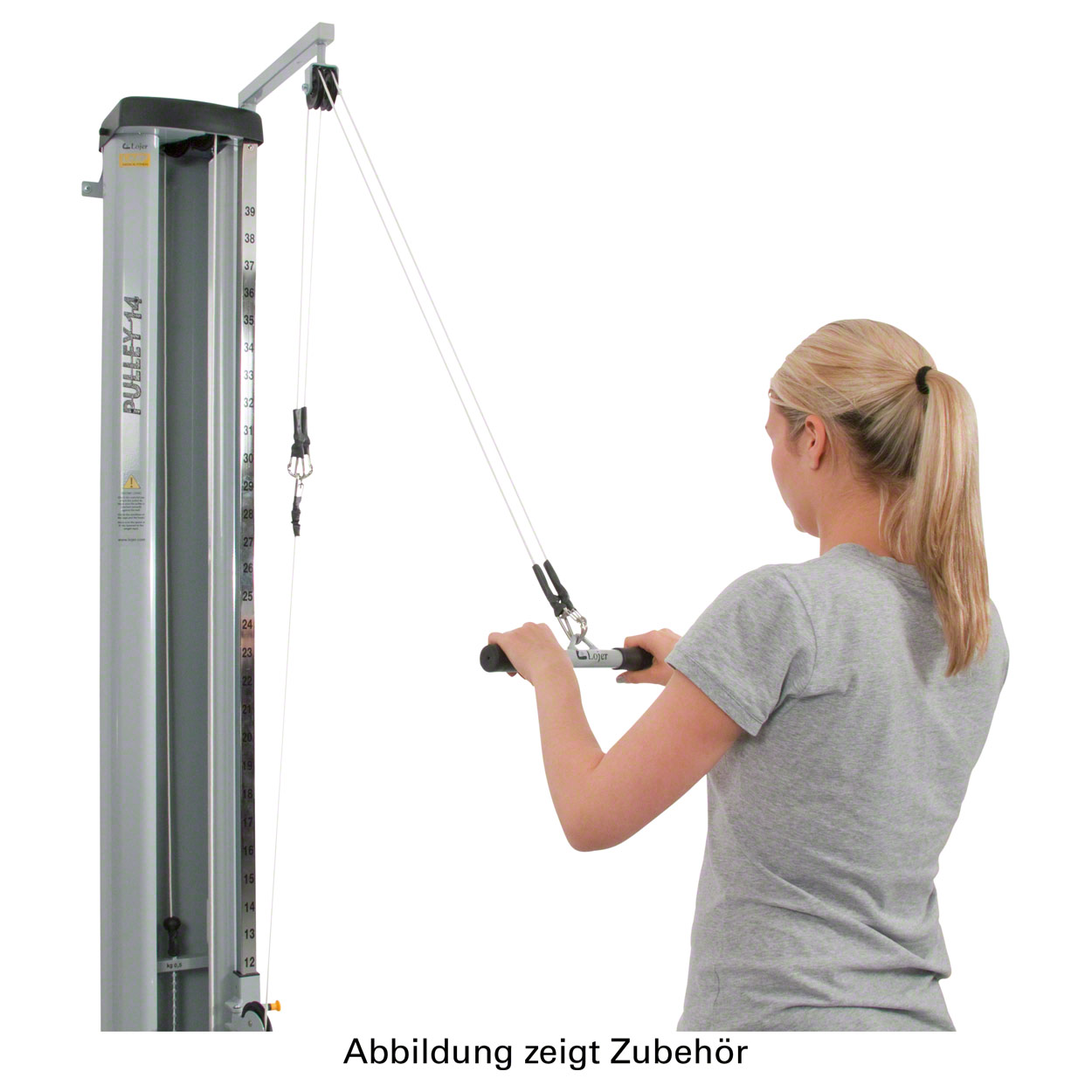 A blonde woman is training on a cable machine with a pulley block. She is pulling a bar, which runs over the top of the pulley block on the grey machine, from top to bottom. The machine is labelled ‘PULLEY 14’ and has a scale on the side.
