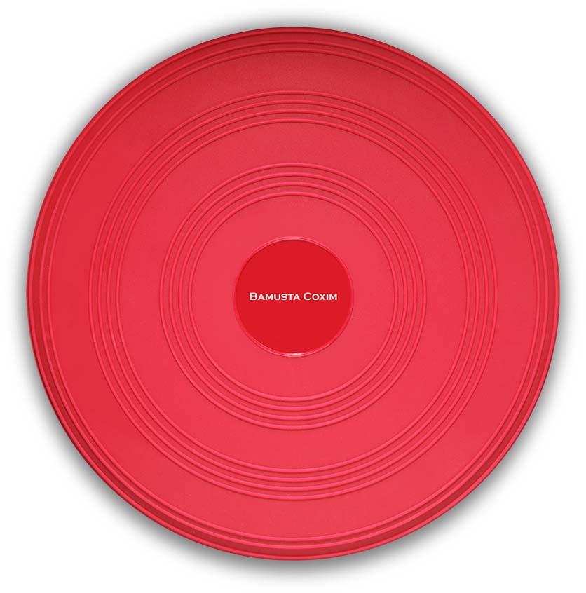 A red, round balance cushion with a smooth surface and concentric grooves. In the centre of the cushion is a red circle bearing the white lettering ‘BAMUSTA COXIM’, which clearly identifies the product.