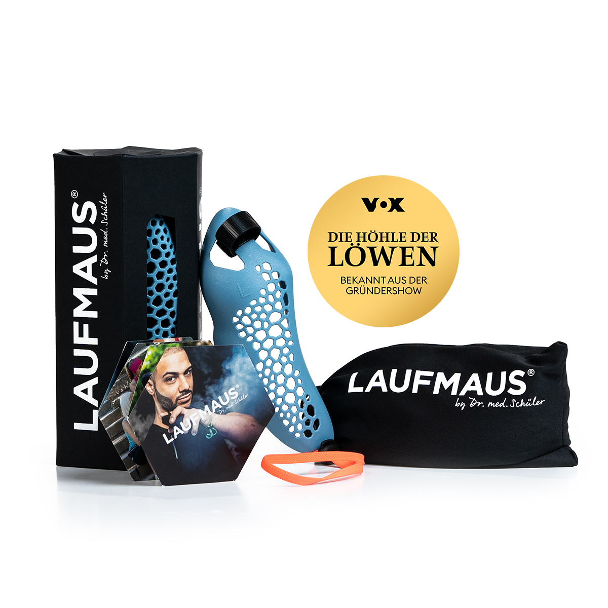 Souris de course ergonomique bleu clair avec motif en nid d'abeille sur fond blanc. À côté, un emballage noir, un sac en tissu noir, un bracelet en silicone orange et un dépliant hexagonal. À l'arrière-plan, un autocollant doré « Die Höhle der Löwen ».