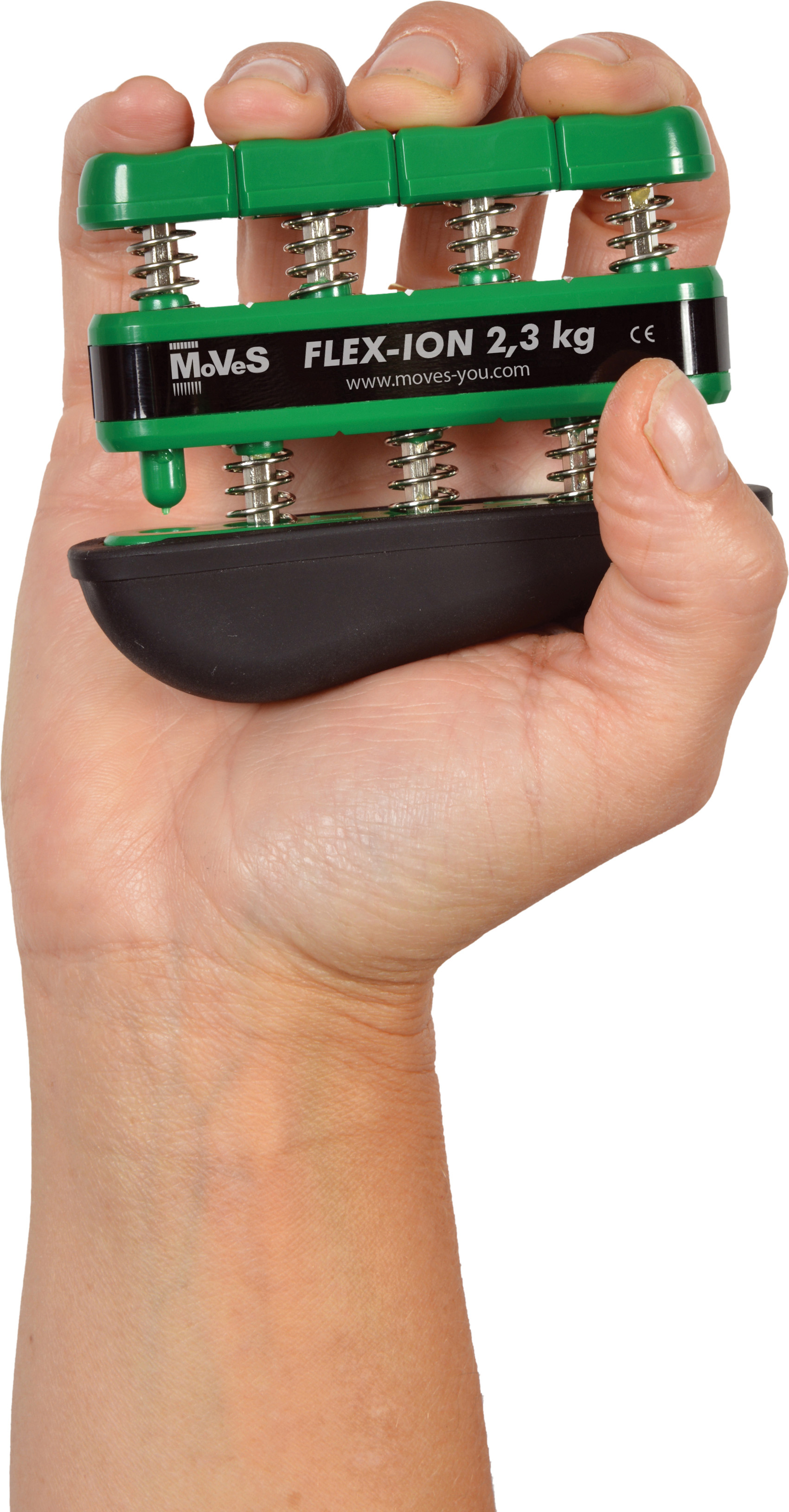 A right hand is holding a green Moves Flex-Ion hand trainer. The fingers are pressing four spring-loaded buttons. The black base is ergonomically shaped. Model FLEX-ION 2.3 kg, for strengthening and finger rehabilitation following injuries.