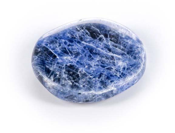 Pierre précieuse en sodalite bleu foncé, polie lisse, présentant de fines lignes irrégulières blanches et bleu clair qui forment un motif marbré. Forme ovale plate légèrement irrégulière, reflétant doucement la lumière, sur fond clair.