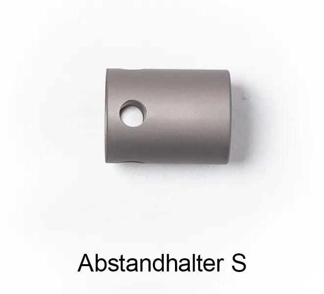 Kleiner zylindrischer Abstandhalter S aus dunkelgrauem Metall mit matter Oberfläche. Mit kreisförmiger Öffnung zur Aufnahme bzw. präzisen Führung eines Laserstrahls. Zubehör für das qmd helios Lasertherapie-Gerät.