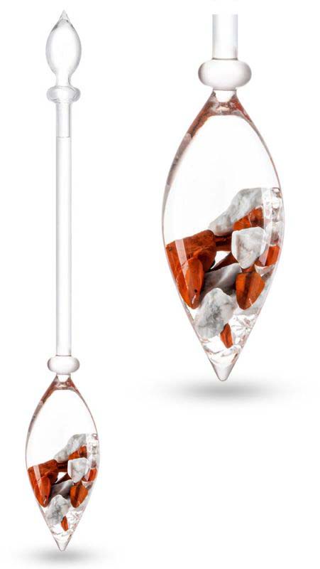 Bastoncino di pietre preziose in vetro trasparente con fiala a goccia in basso, contenente corniola rosso-arancio e calcite arancione, oltre a pezzetti di giada chiara e cristallo di rocca. A destra, primo piano.