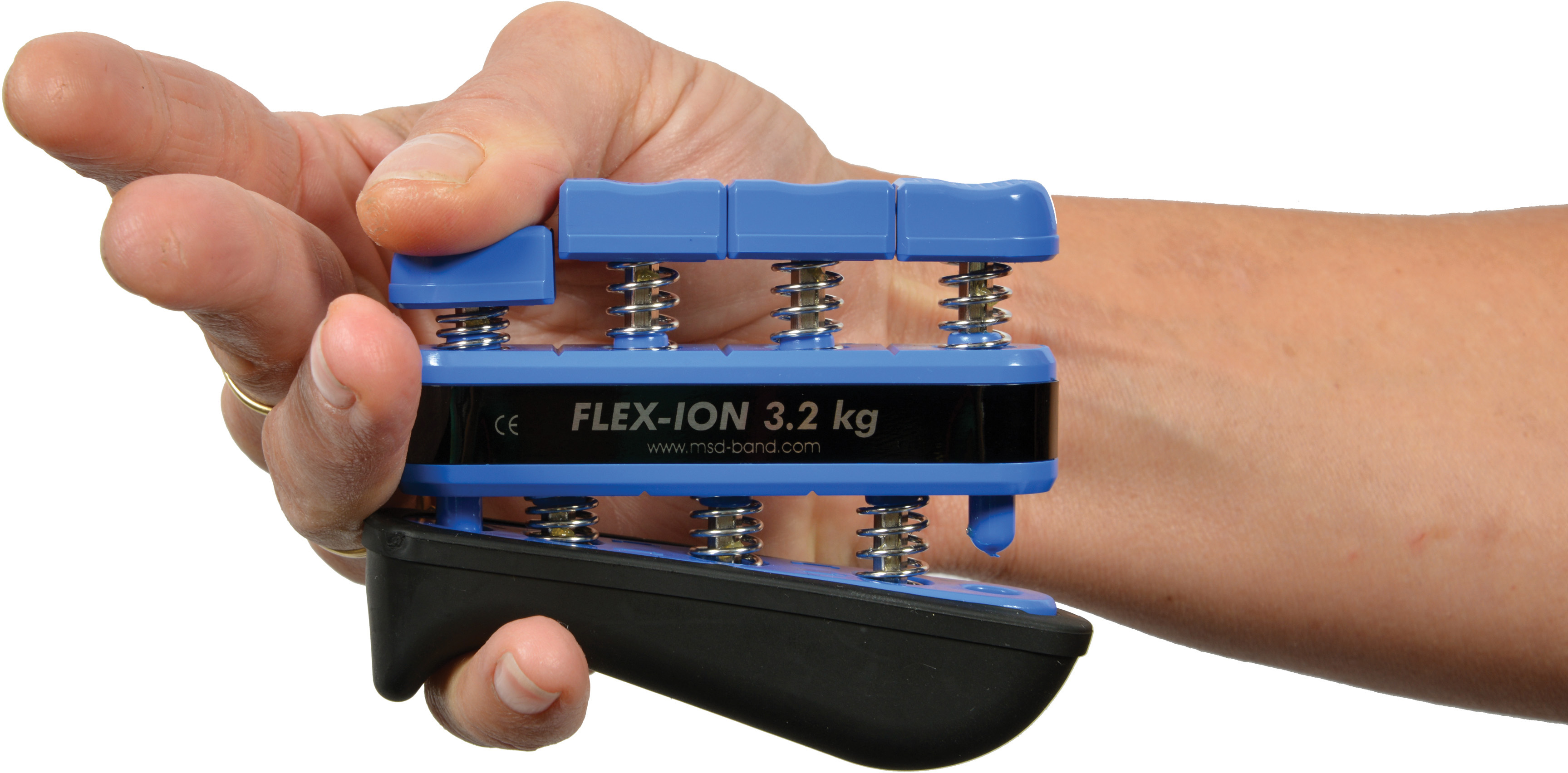 A hand holds a blue Moves Flex-Ion hand trainer with four spring-loaded buttons for personalised finger strength training. The black central section reads ‘FLEX-ION 3.2 kg’ to show the resistance level. Ergonomic design.