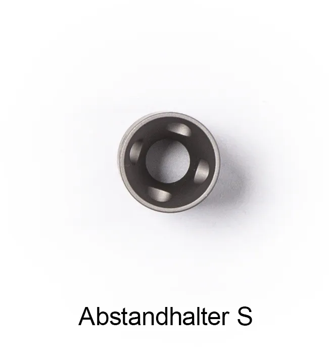 Kleiner, zylindrischer Abstandhalter Grösse S aus dunkelgrauem Metall, Draufsicht. Zentral eine grosse runde Öffnung, umgeben von mehreren kleinen, gleichmässig verteilten kreisförmigen Aussparungen. Zubehör fürs qmd® helios Lasertherapie-Gerät.